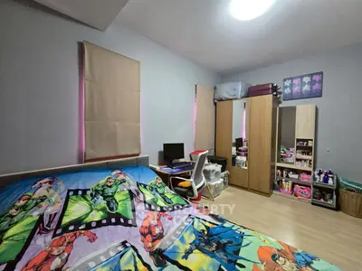 Cozy bedroom with superhero-themed bedding and ample storage space