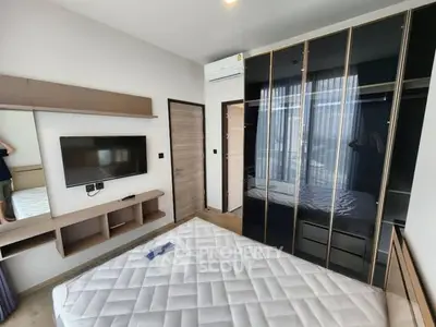 Modern bedroom with built-in wardrobe and wall-mounted TV