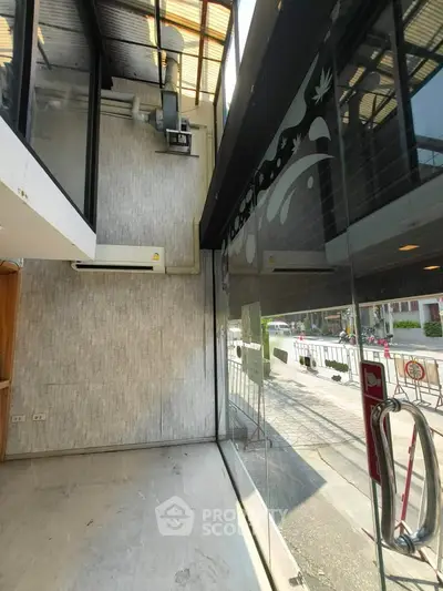 Modern glass entrance with street view, featuring sleek design and ample natural light.