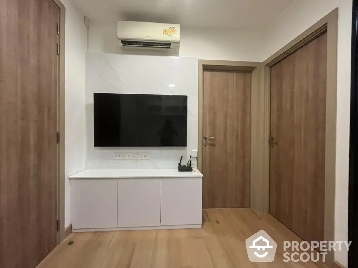 Modern living room with wall-mounted TV and air conditioning unit