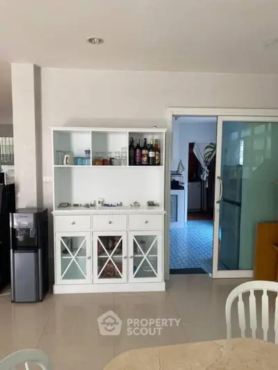 Spacious living area with stylish cabinet and sliding glass door