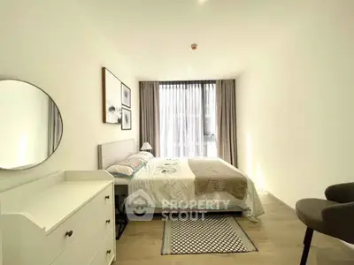 Bright and modern bedroom with stylish decor and large window in a contemporary apartment.