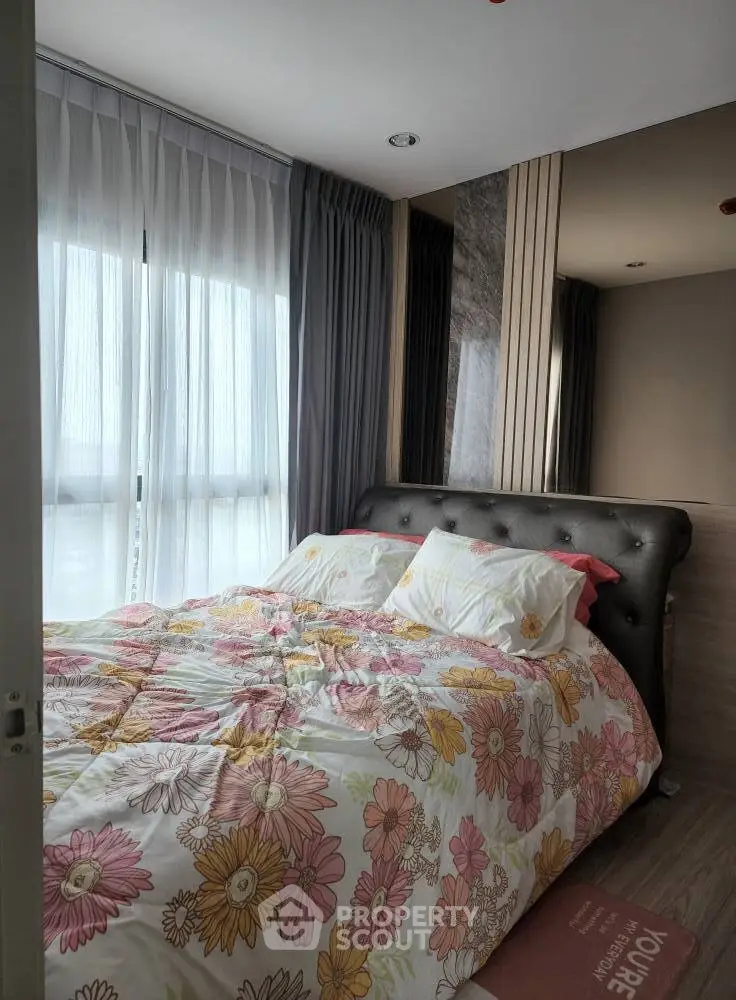 Cozy bedroom with floral bedding and large windows for natural light