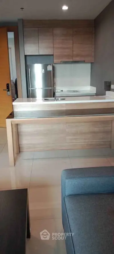 Modern kitchen with sleek cabinetry and stainless steel appliances in a stylish apartment.