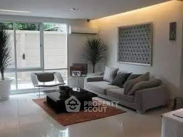 Modern living room with sleek furniture and large window for natural light.