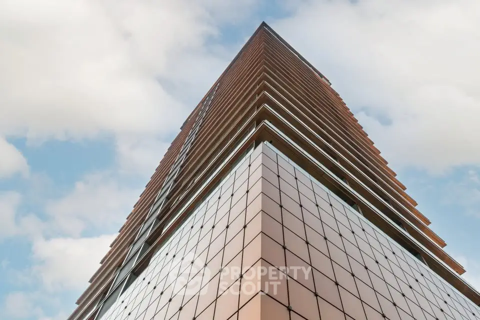 Modern architectural building with sleek design and glass facade against a blue sky.