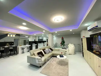 Spacious modern living room with open kitchen and stylish lighting