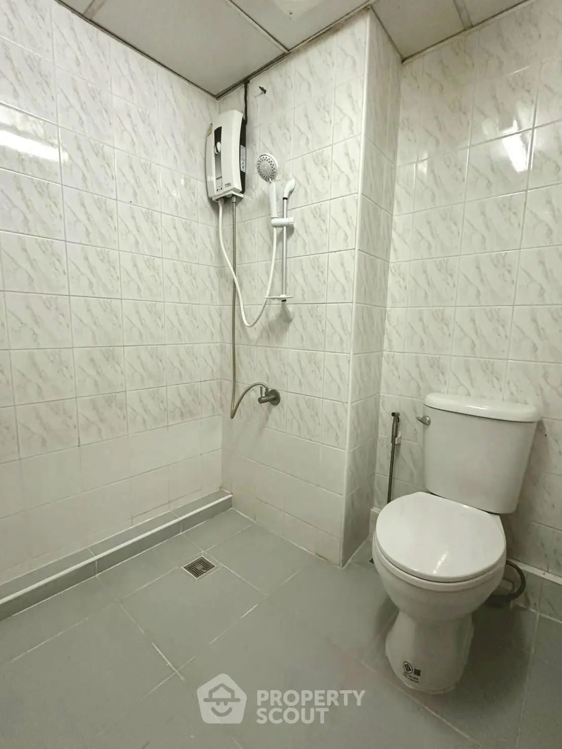 Modern bathroom with tiled walls and electric shower