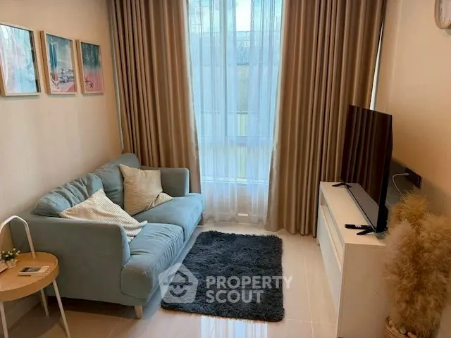 Cozy living room with plush sofa, stylish decor, and natural light through large window.