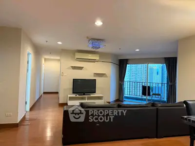Spacious living room with modern decor and balcony view in high-rise apartment.