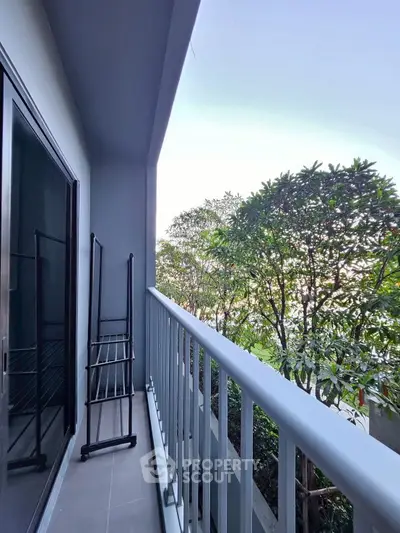 Charming balcony with lush greenery view, perfect for relaxation and enjoying nature.