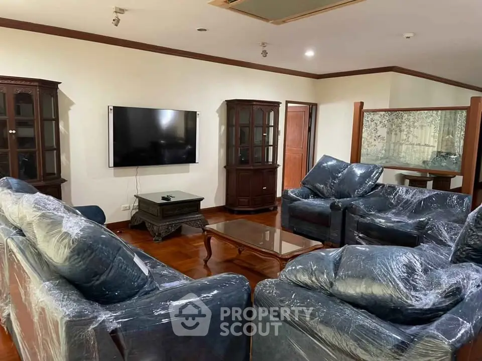 Spacious living room with elegant furniture and wall-mounted TV, perfect for relaxation and entertainment.