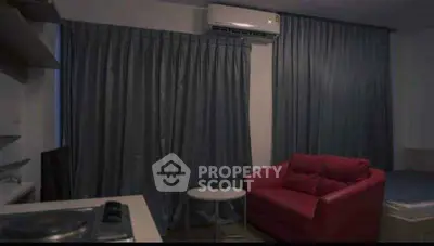 Cozy living room with red sofa and air conditioning, perfect for relaxation.