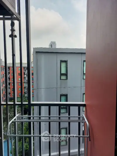 Urban apartment balcony with city view and modern architecture.