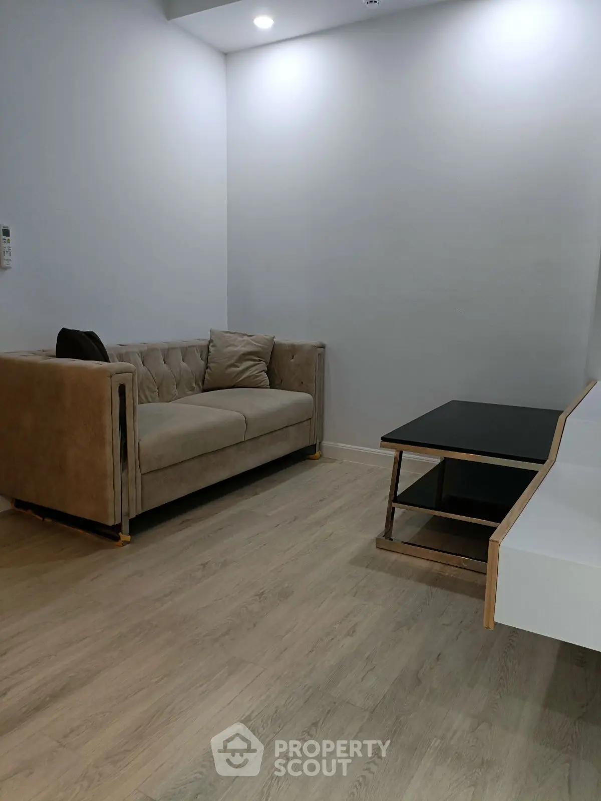 Modern living room with stylish sofa and sleek coffee table on wooden flooring.