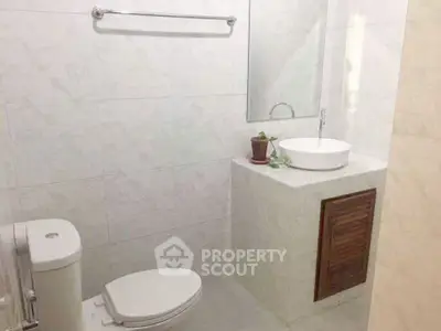 Modern bathroom with sleek white fixtures and minimalist design.
