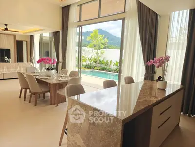 Luxurious open-plan living room with pool view and elegant dining area.