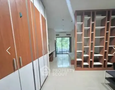 Spacious modern living room with built-in shelves and large windows for natural light.