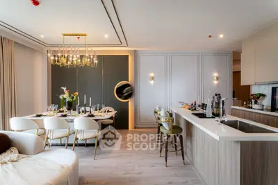 Luxurious open-plan kitchen and dining area with elegant decor and modern lighting.