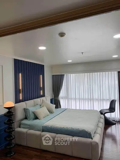 Luxurious bedroom with modern decor and large window for natural light