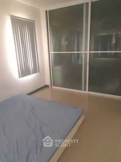 Minimalist bedroom with large frosted glass sliding doors and natural light.