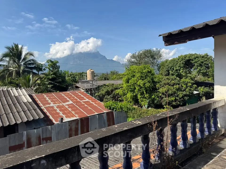 Scenic balcony view with lush greenery and mountain backdrop, perfect for nature lovers.