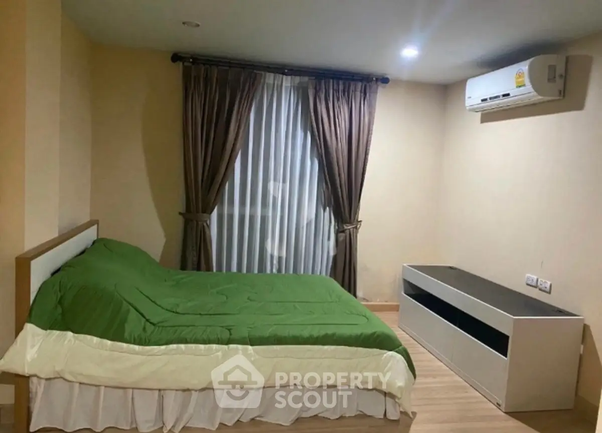 Cozy bedroom with green bedding and air conditioning, perfect for restful nights.