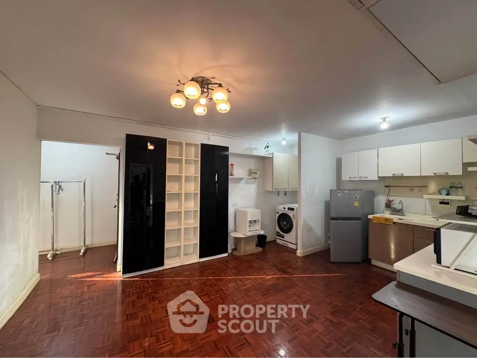 Spacious open-plan living area with modern kitchen and parquet flooring