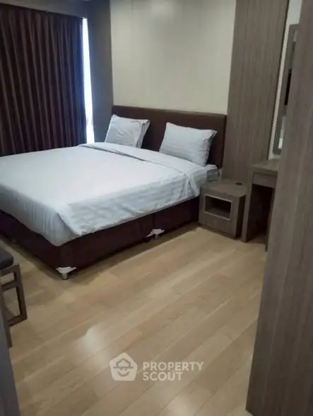 Modern bedroom with wooden flooring and elegant furnishings