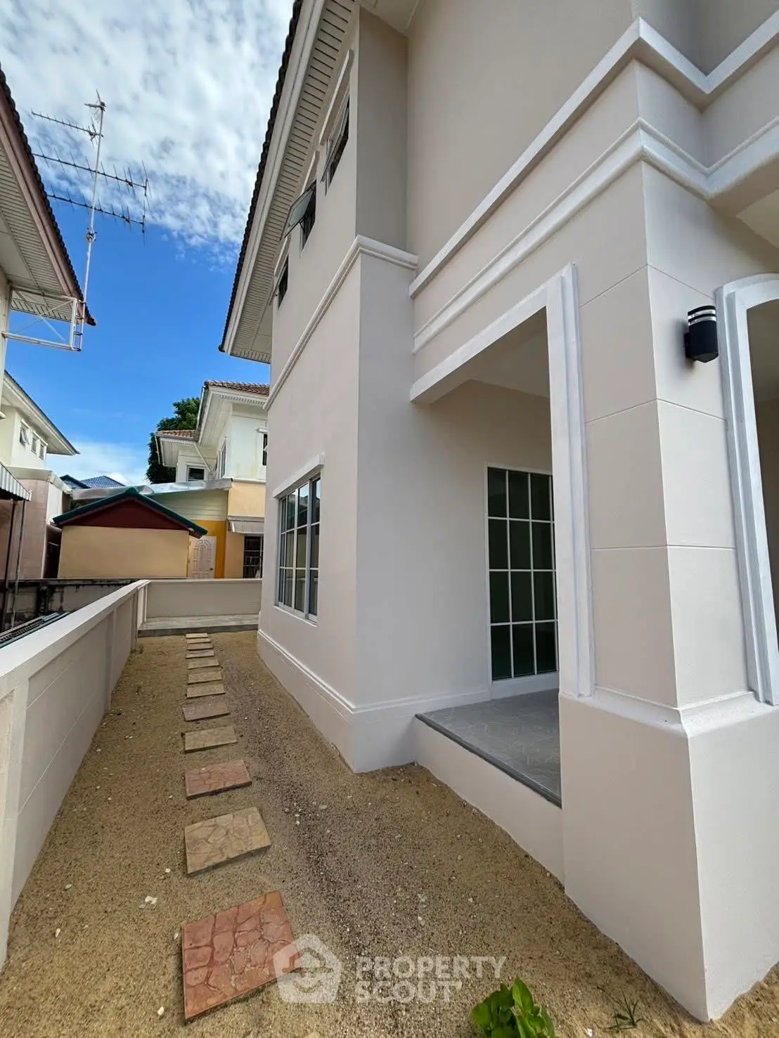 Modern two-story house exterior with clean lines and a small garden path.