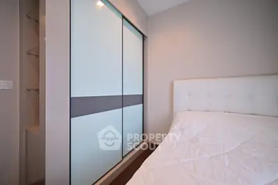 Modern bedroom with sleek sliding closet doors and cozy bed