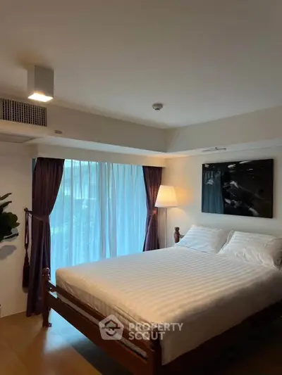 Cozy bedroom with elegant decor and large window for natural light