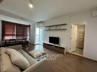 Spacious living room with modern decor and natural light in a stylish apartment.