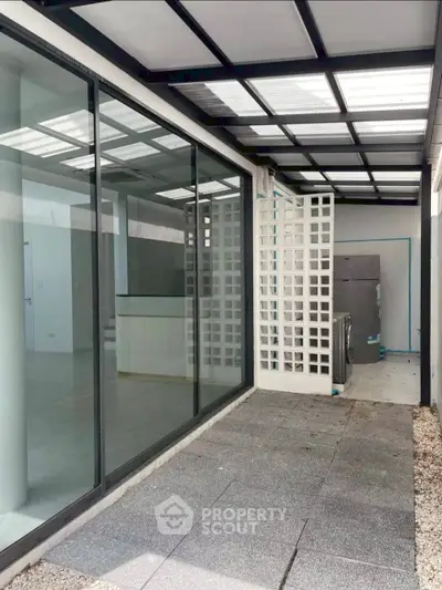Modern covered patio with glass doors and stylish lattice wall in contemporary home.