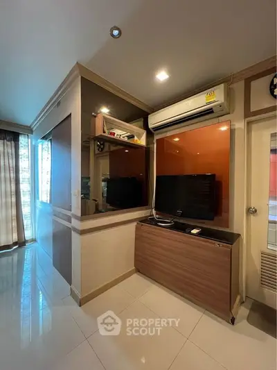Modern living room with air conditioning and TV unit, featuring stylish decor and natural light.