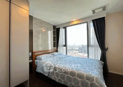 Modern bedroom with large window offering stunning city view and stylish decor.