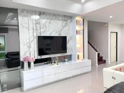 Modern living room with marble TV wall and sleek white cabinetry