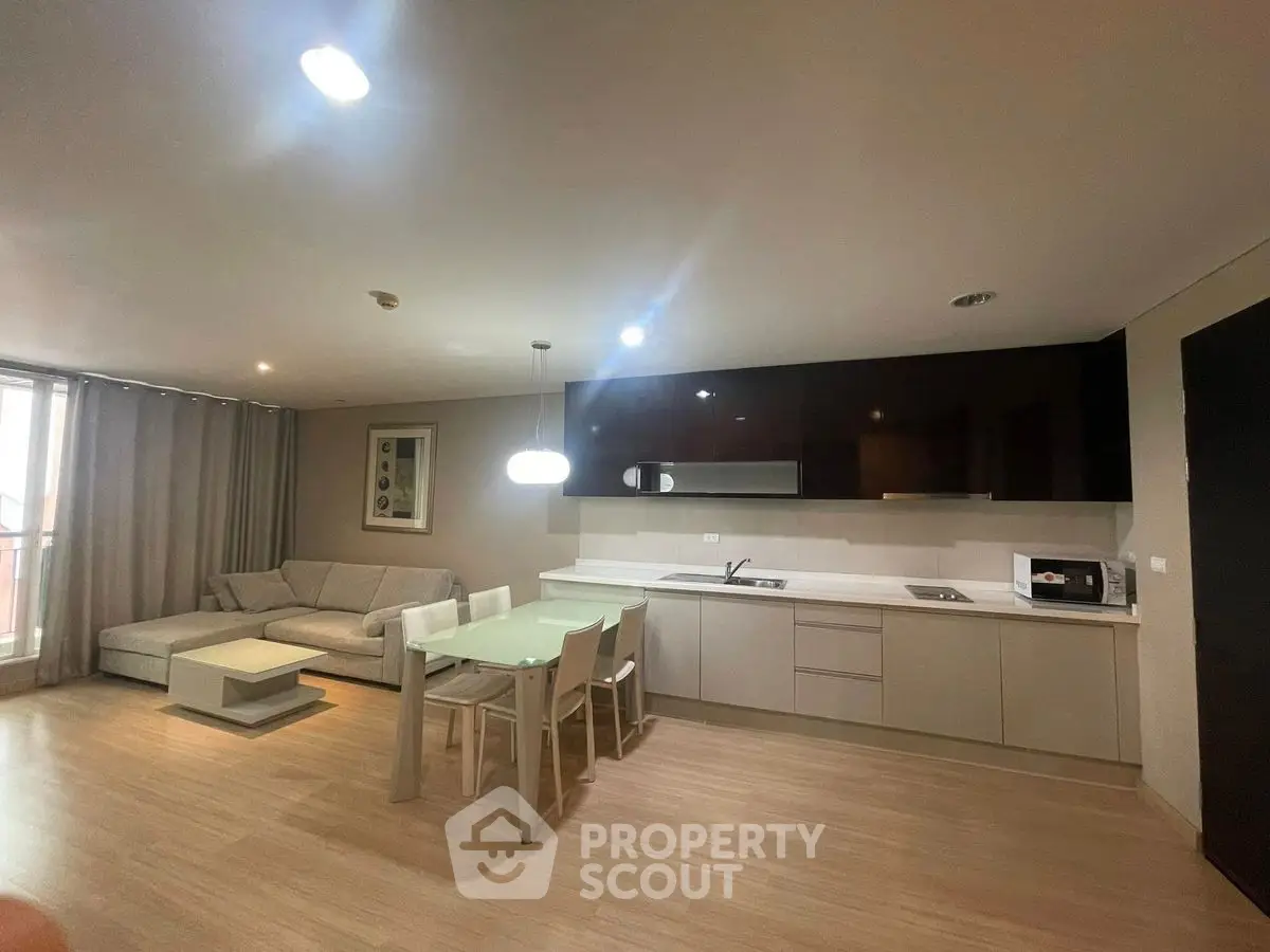 Modern open-plan living room and kitchen with sleek design and cozy ambiance.