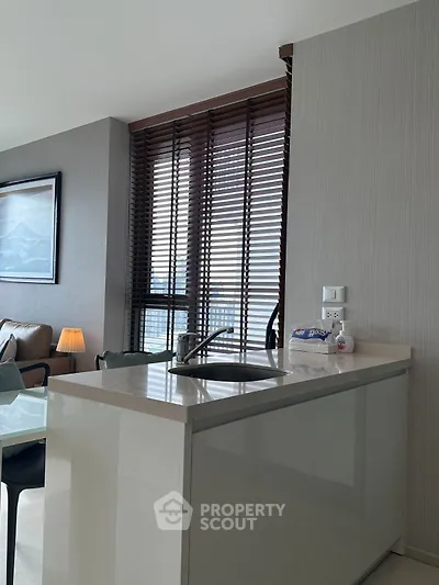 Modern kitchen with sleek island and large windows in a stylish apartment.