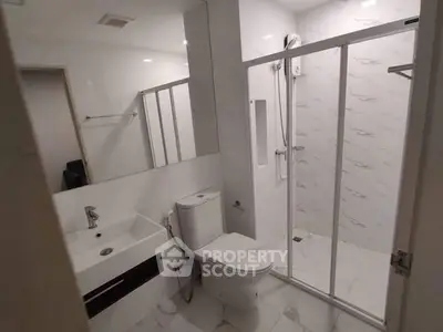 Modern bathroom with sleek shower enclosure and contemporary fixtures.