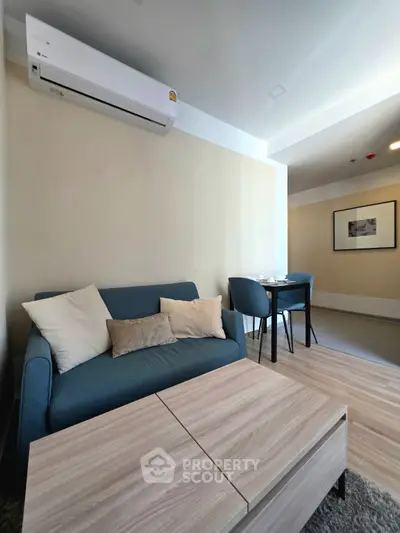 Modern living room with cozy sofa and dining area in open layout apartment.