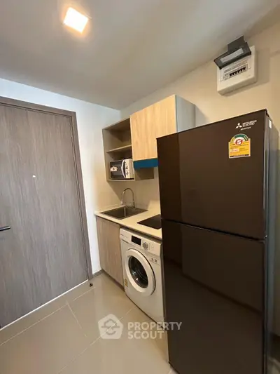 Modern kitchen with sleek appliances and ample storage in a compact layout.