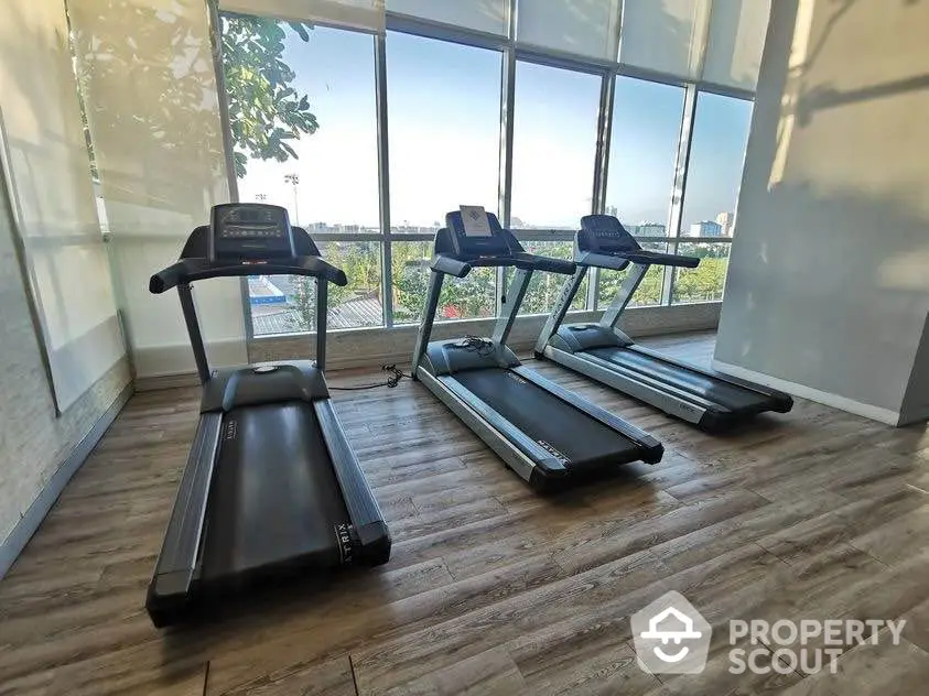 Modern gym with treadmills and large windows offering scenic views