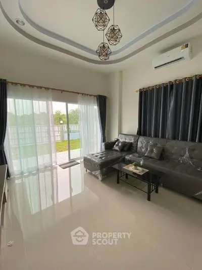 Modern living room with stylish decor and large windows overlooking garden