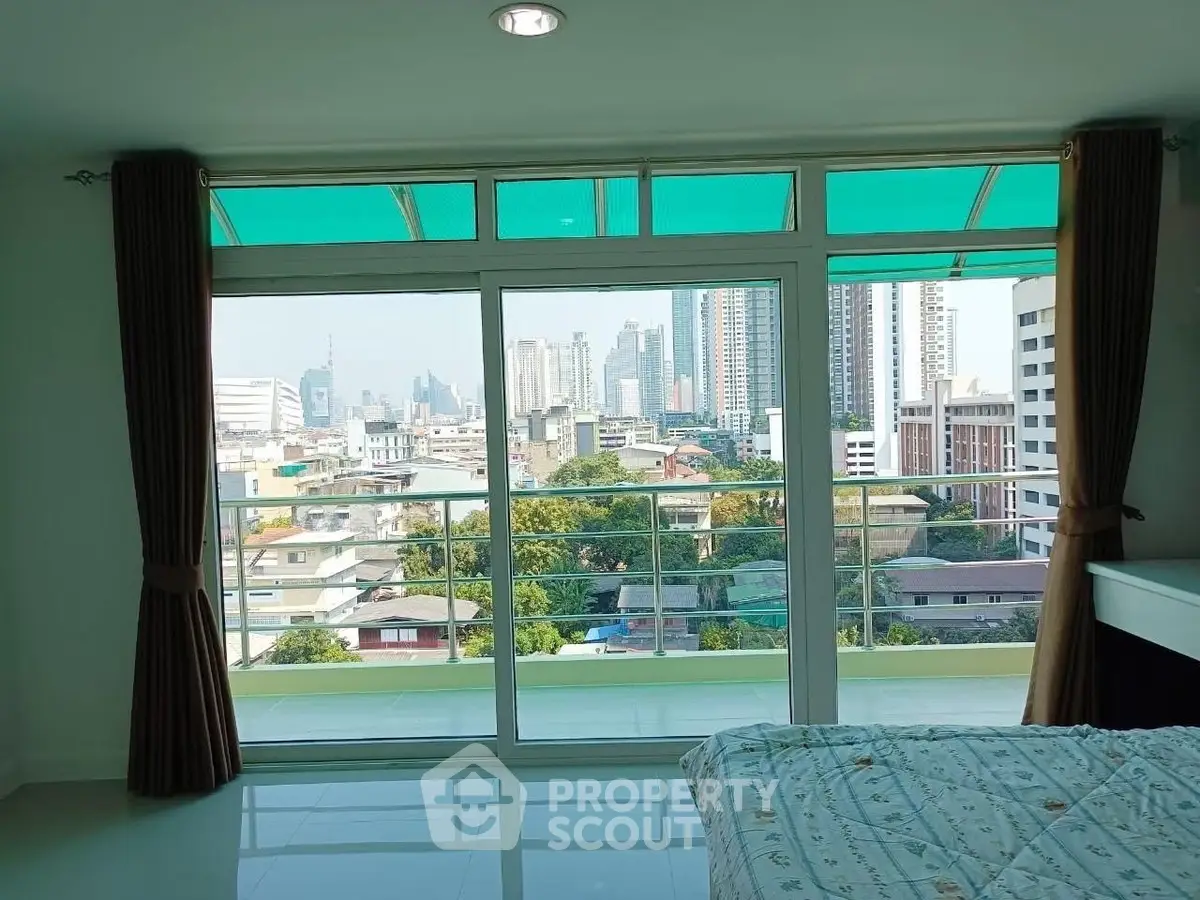 Spacious bedroom with stunning city view and large balcony access.