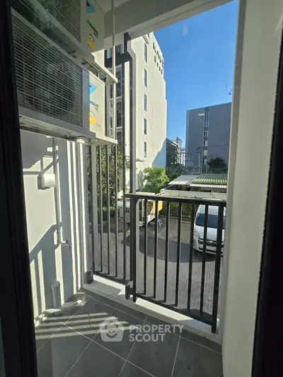 Cozy balcony with city view and air conditioning unit, perfect for urban living.