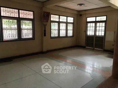 Spacious empty room with large windows and tiled floor, ideal for customization.