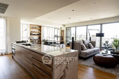 Luxurious open-plan living room with modern kitchen and large balcony access.