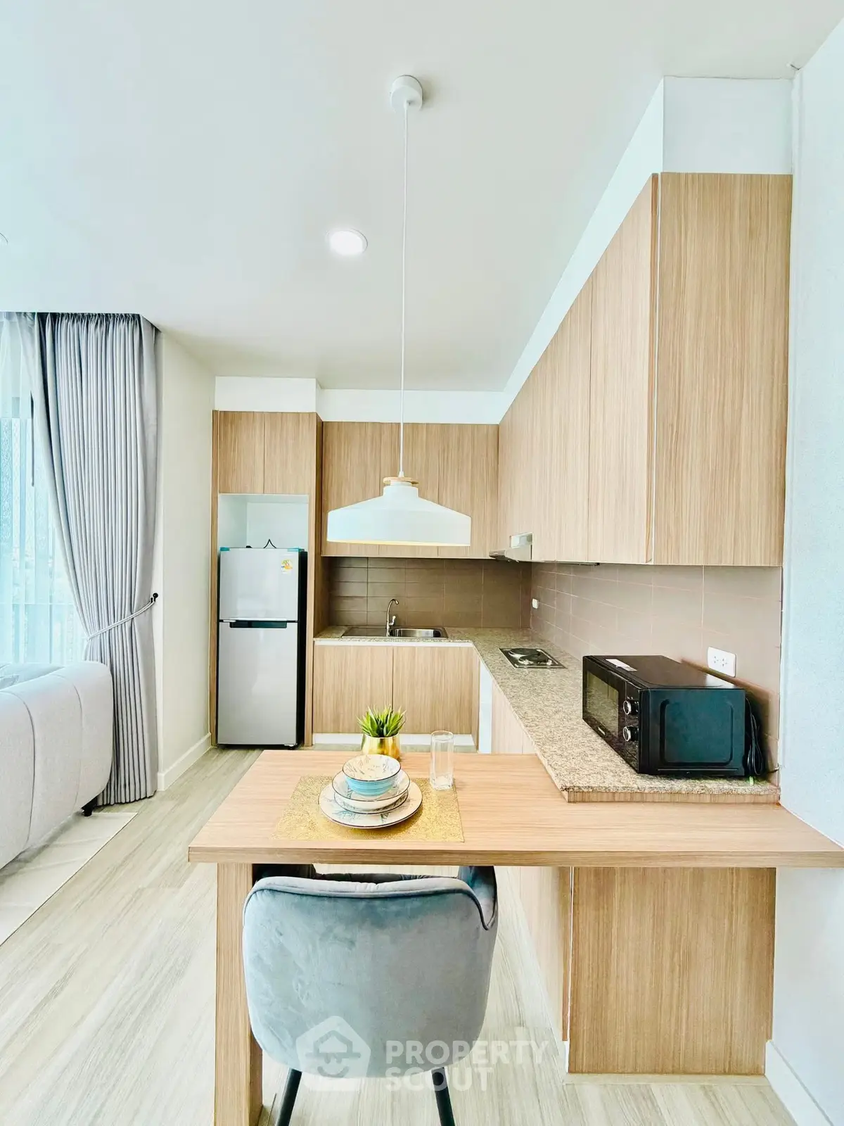 Modern kitchen with wooden cabinets and sleek appliances in a cozy apartment