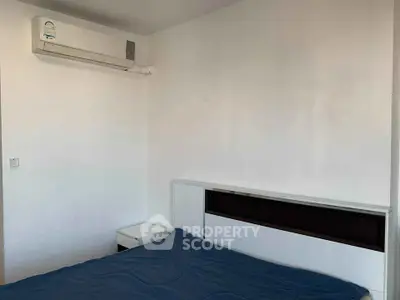 Minimalist bedroom with air conditioning and modern furniture, perfect for a cozy living space.